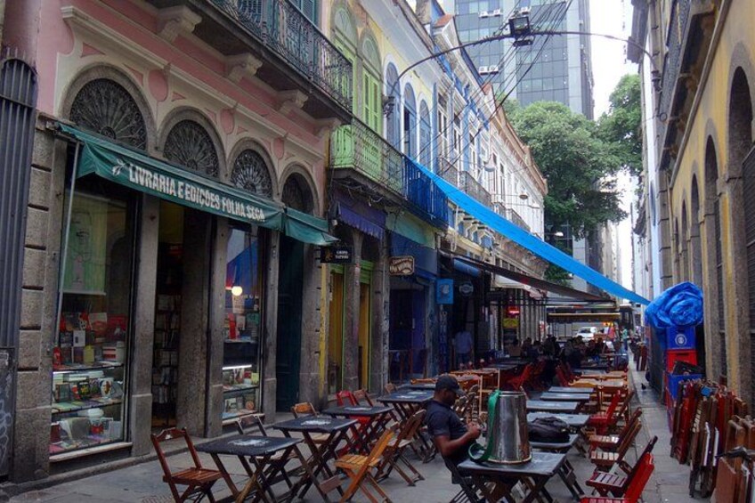 A street with outdoor seating, shops, and a blue awning. 5