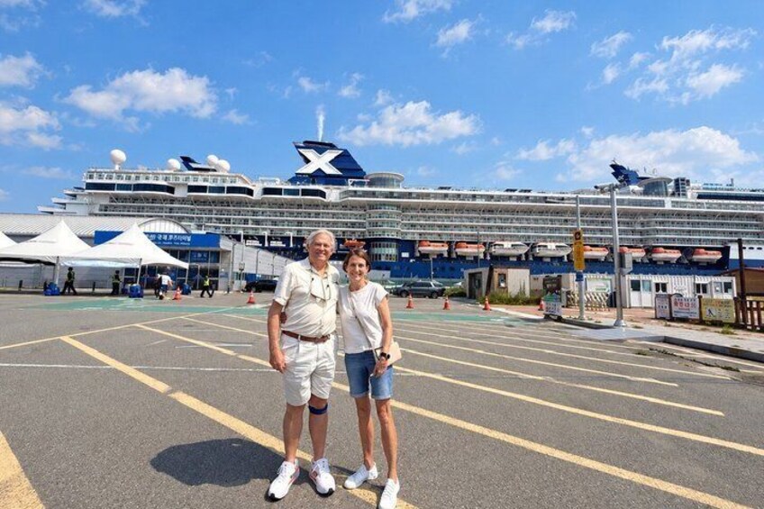 A cruise ship docked at a port with a clear sky. 1