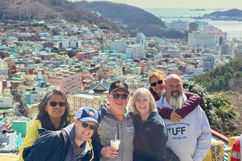 A group of people posing for a photo with a cityscape in the background. 3