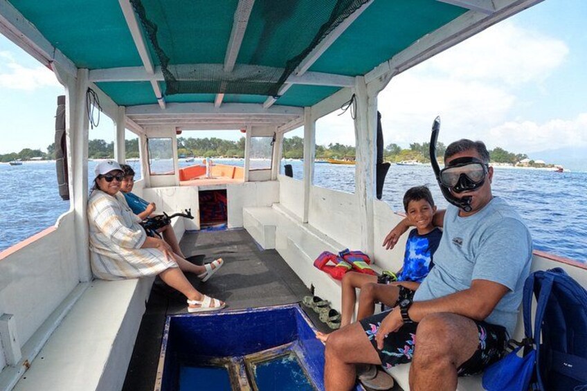 A boat with people sitting on the deck, a blue container, and a person wearing a snorkel mask. 4
