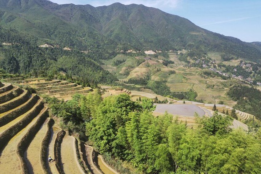 Terraced fields, a small pond, and a mountain range. 3