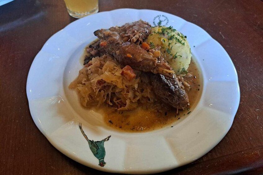 A plate of food with sauerkraut, meat, and mashed potatoes. 5