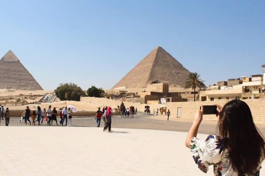 The Great Pyramids of Giza with tourists walking around. 5