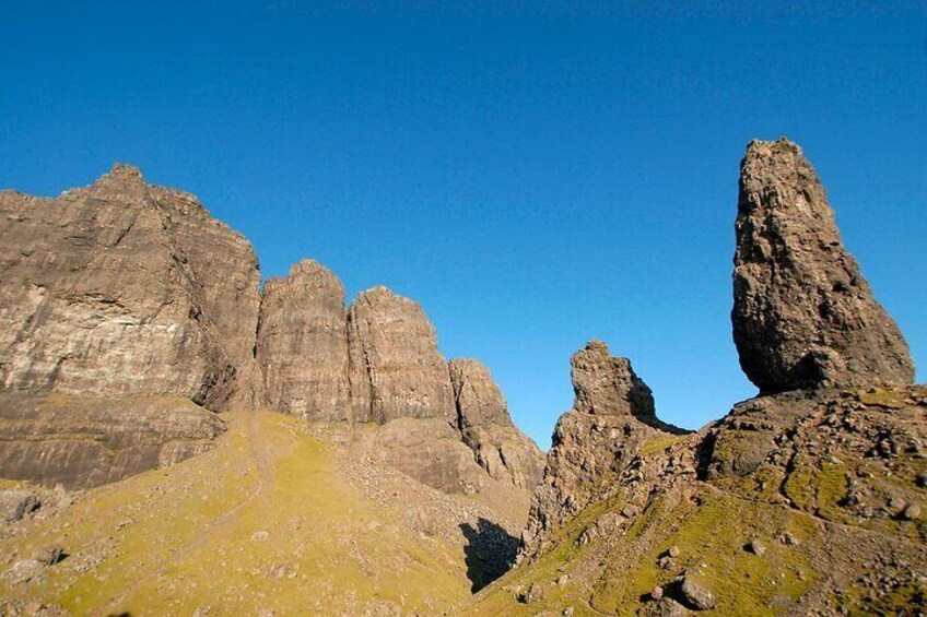 A rocky mountain landscape with prominent cliffs and a clear blue sky. 5