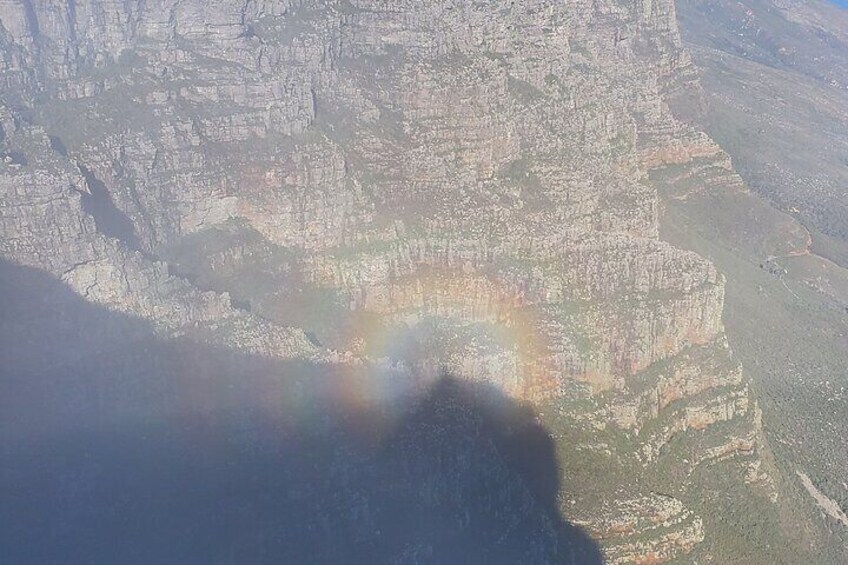 A canyon with layered rock formations and a rainbow. 5
