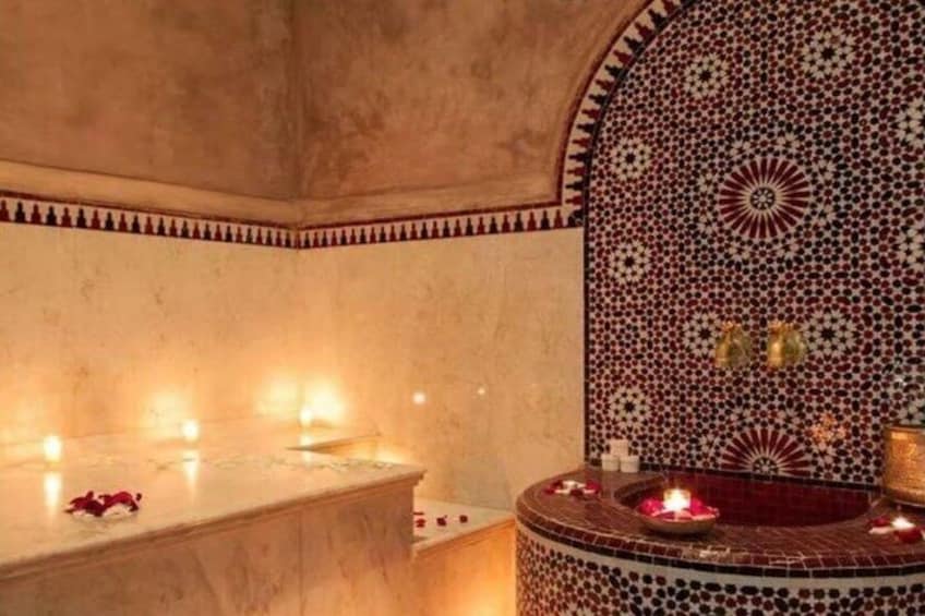 A bathroom with a marble sink, a mosaic wall, and candles. 2