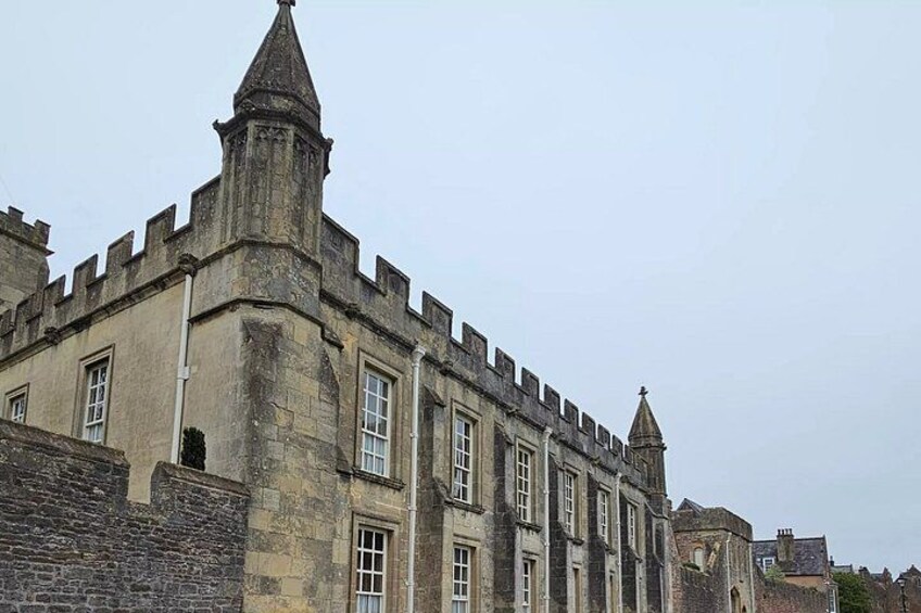 A historic stone building with battlements and a tower. 5