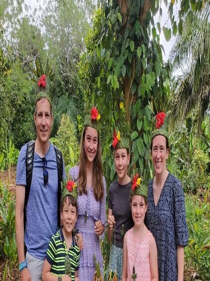 A group of people in a garden with dense foliage and trees in the background. 4