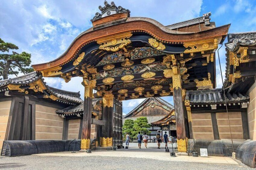 Une porte japonaise traditionnelle, ornée de motifs décoratifs et surmontée d’un toit en tuiles. 5