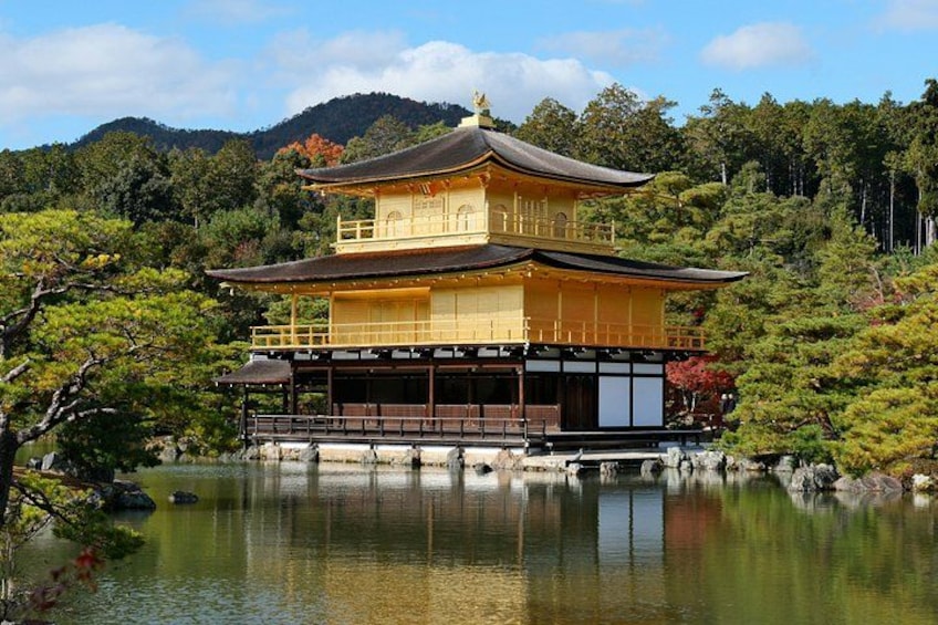 Un bâtiment japonais traditionnel à la façade dorée, entouré d’un lac paisible et d’une végétation luxuriante. 4