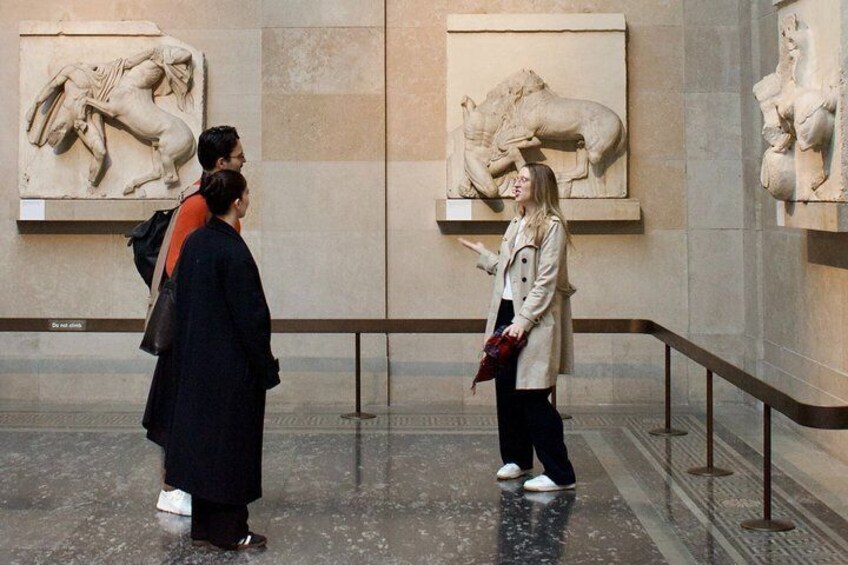 A museum interior with classical sculptures on display. 1