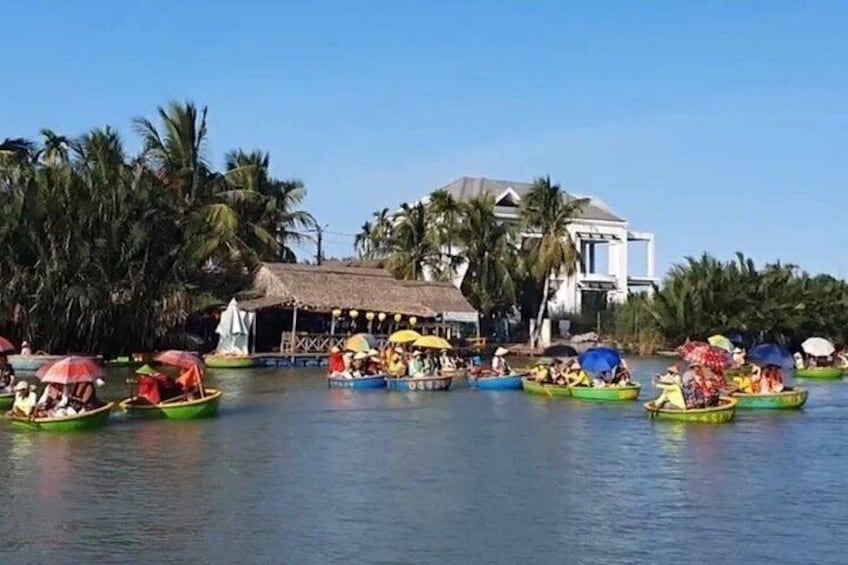 A group of colorful boats on calm water, surrounded by palm trees and a building with a thatched roof. 4