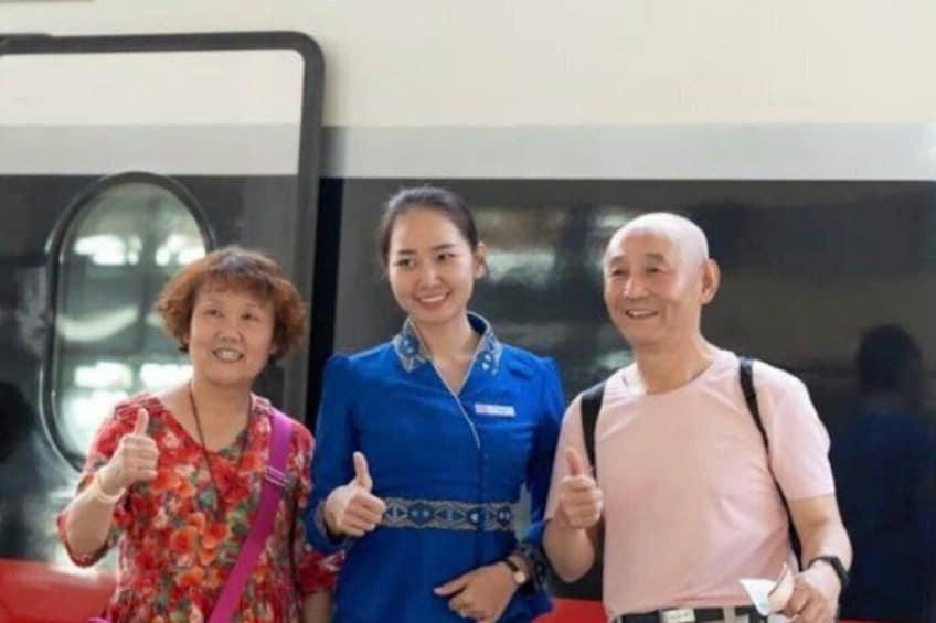Three people standing in front of a bus. 1
