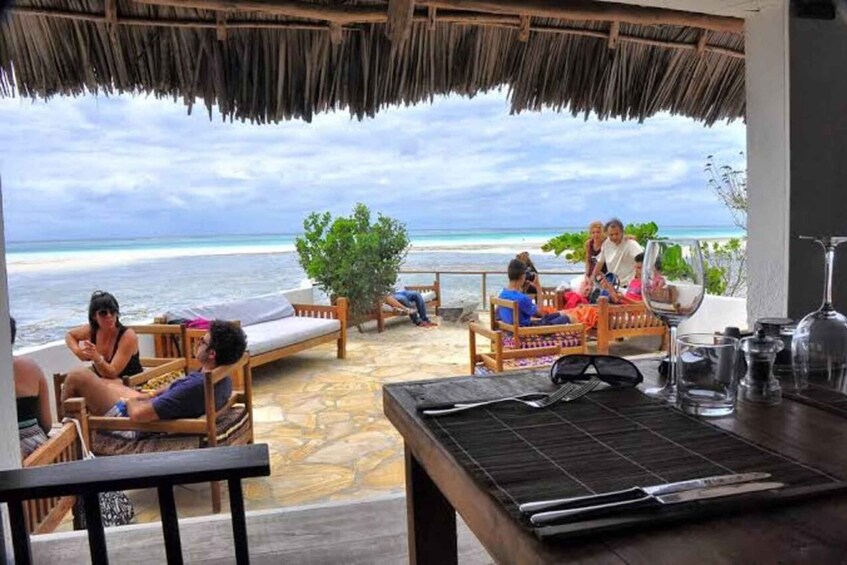 A beachside lounge with wooden furniture and a view of the ocean. 3