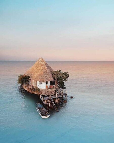A thatched-roof house on stilts in the water. 5