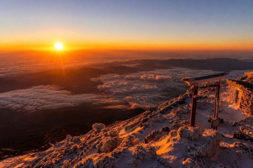 A sunrise over a snow-covered mountain with a wooden structure. 5