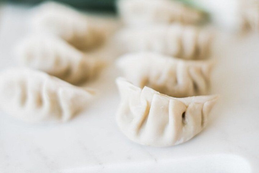 A close-up of dumplings on a white surface. 5