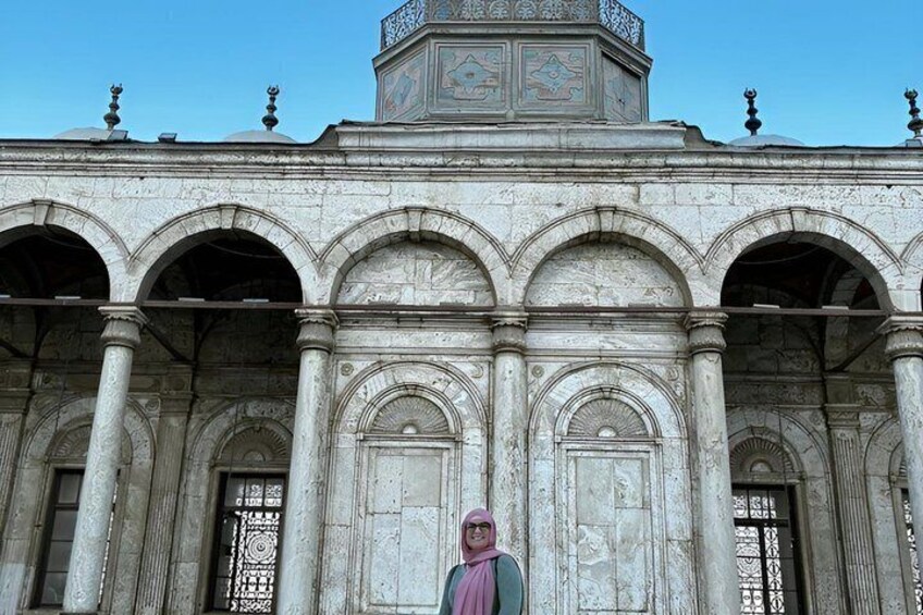 A historical building with arched doorways and a central clock tower. 5