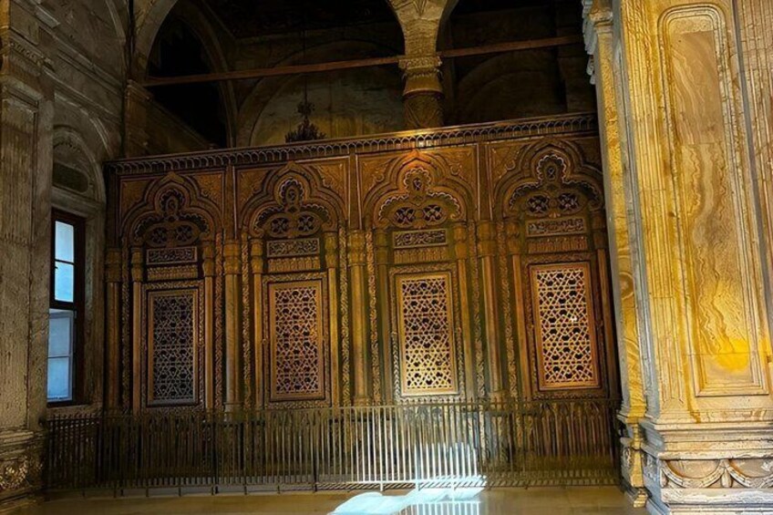 An ornate wooden screen with intricate carvings and lattice windows. 4