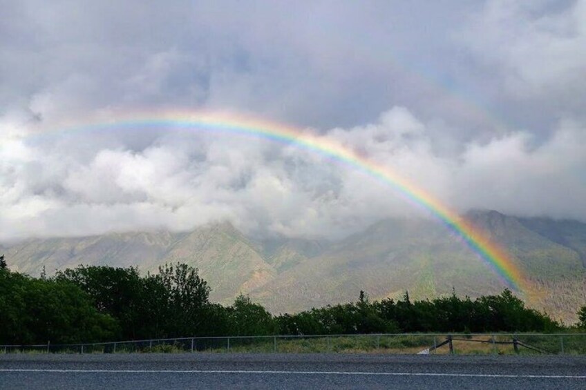 A mountain range with a rainbow arching over it. 3