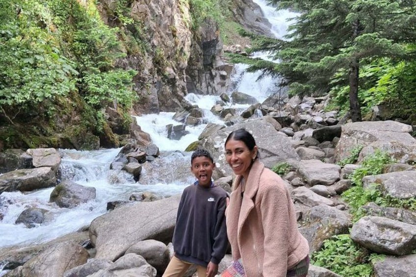 A waterfall surrounded by rocks and greenery. 3