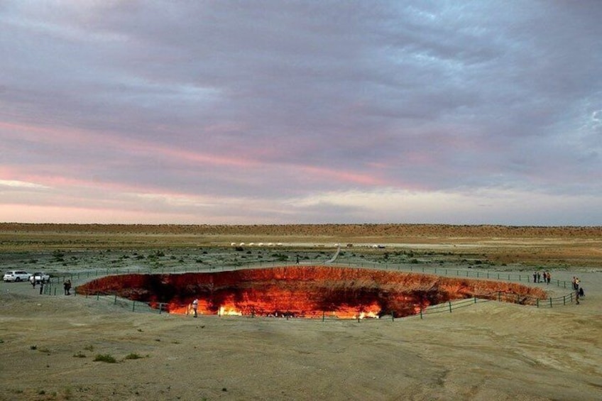 A large, circular fire pit with flames in a desert landscape. 3