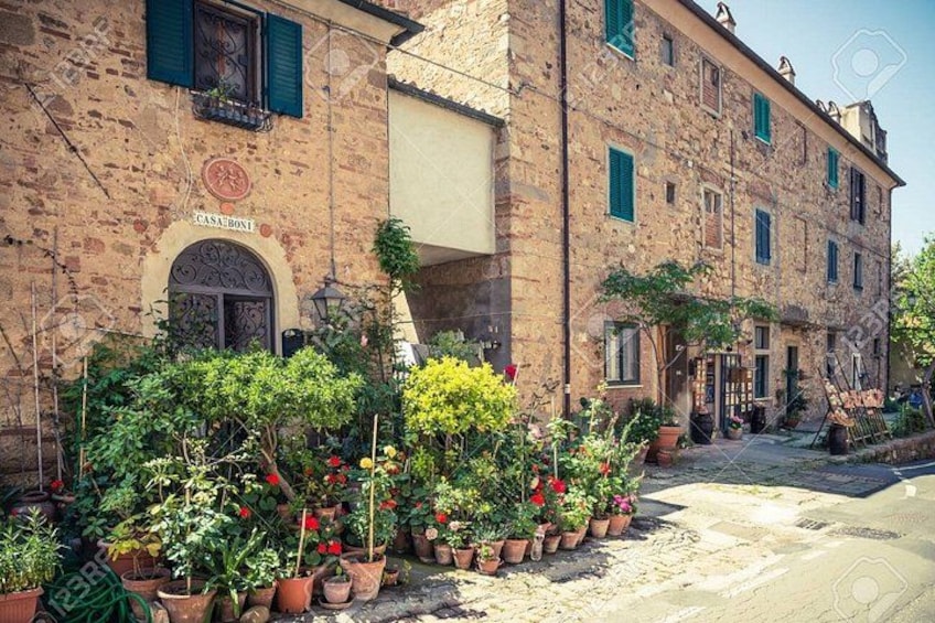 A stone building with a sign reading 'CASA BONI' and potted plants in front. 2