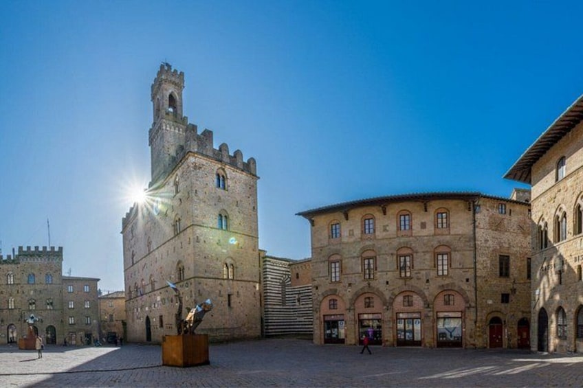 Una plaza histórica con una torre destacada, un amplio espacio abierto y arquitectura clásica. 4