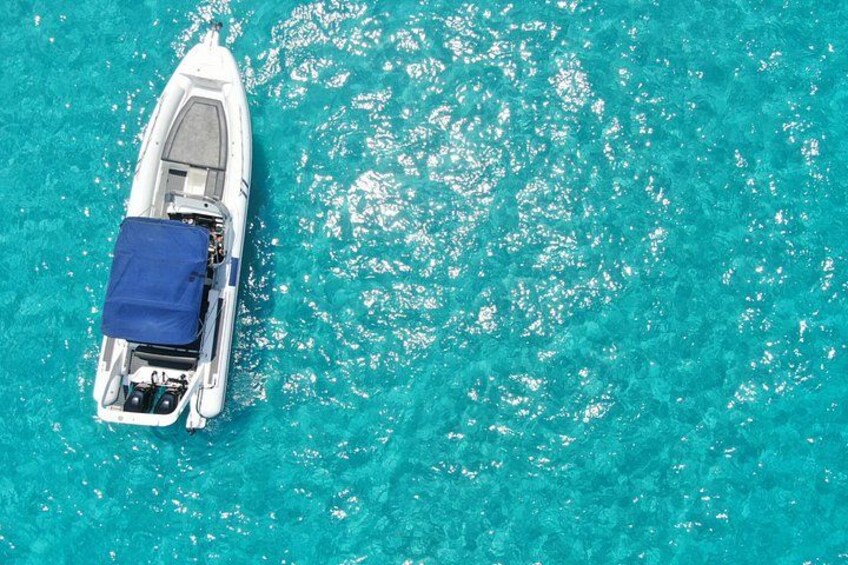 A white boat with a blue cover on turquoise water. 5