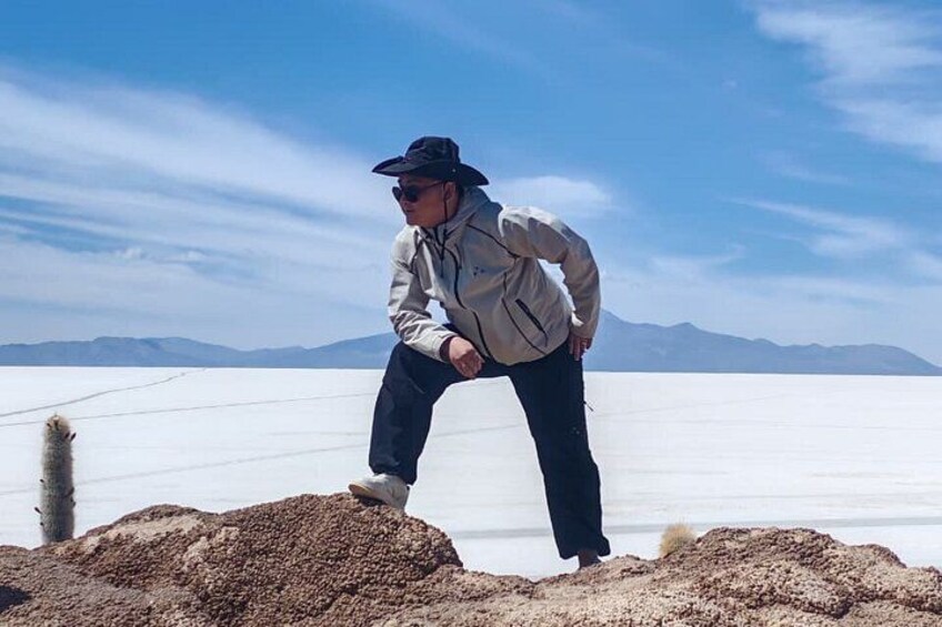 Una persona parada en un desierto de sal con montañas al fondo. 2