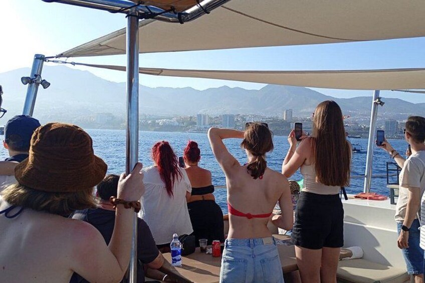 A group of people on a boat with a mountainous landscape in the background. 2