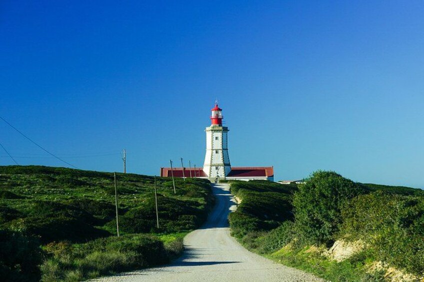 A lighthouse on a hill with a clear sky. 2