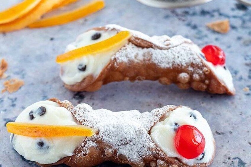 Cannoli with cream filling, chocolate chips, and a cherry on top. 4
