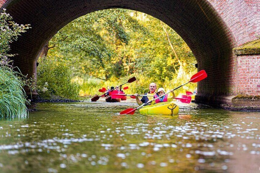 People kayaking under a brick bridge. 5