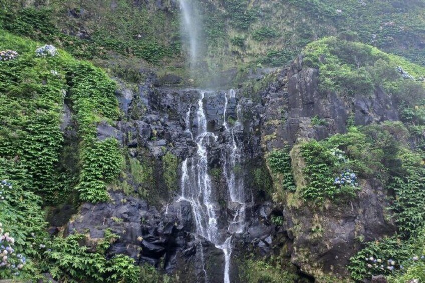 A multi-tiered waterfall surrounded by lush greenery. 5