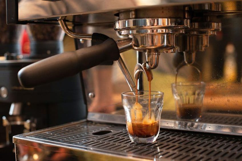 A coffee machine dispensing espresso into a glass cup. 2