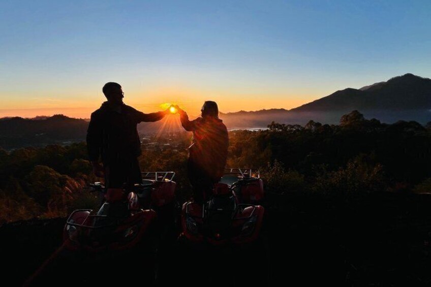 Two people standing on a hill with a sunset in the background. 4