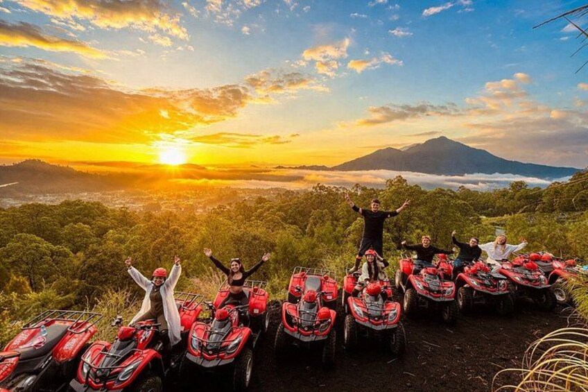 A group of people posing with quad bikes on a hilltop during sunset. 4
