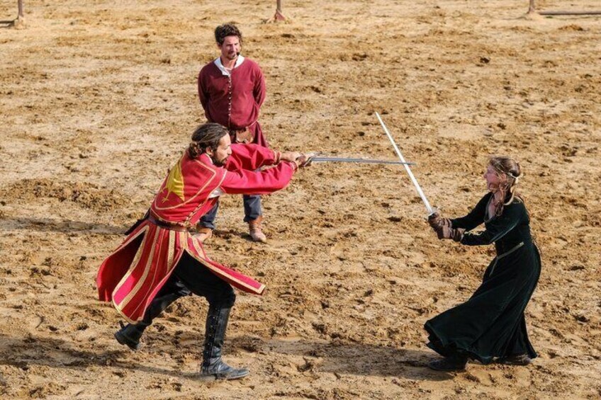 A medieval reenactment with participants in period costumes engaging in a mock battle. 5