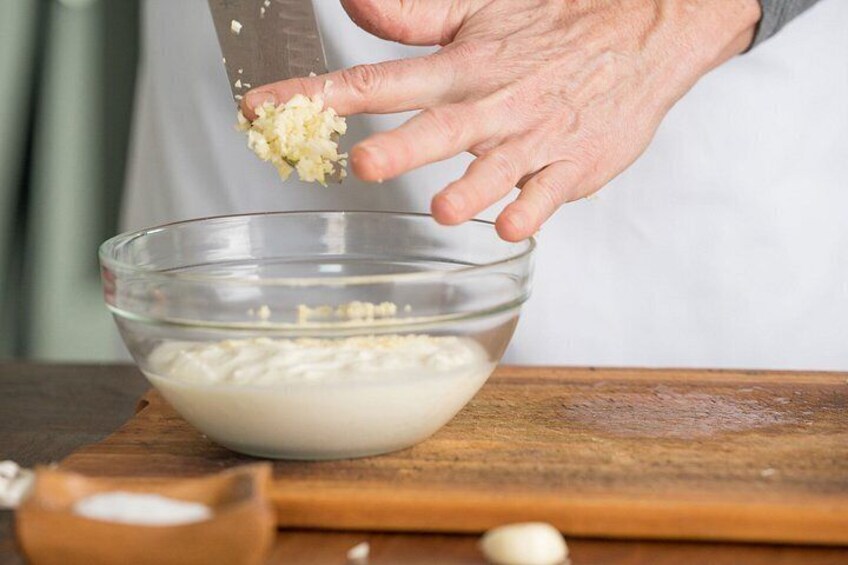 Una persona ralla ajo sobre un cuenco de leche. 5