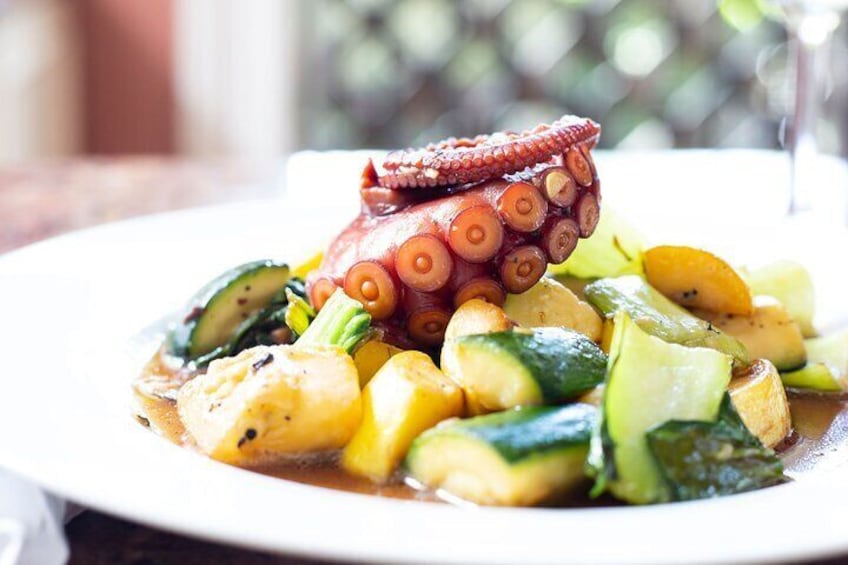 A plate of octopus with vegetables. 4