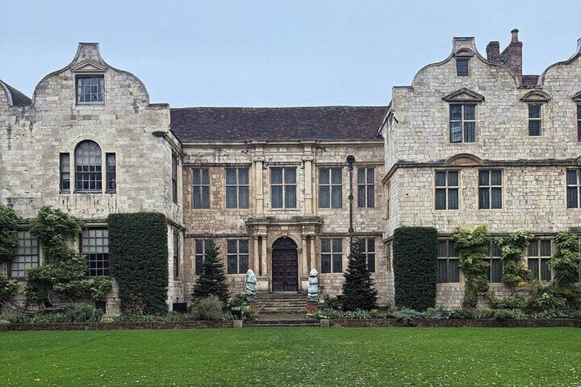 A large stone building with a symmetrical facade, arched windows, and a central entrance. 4