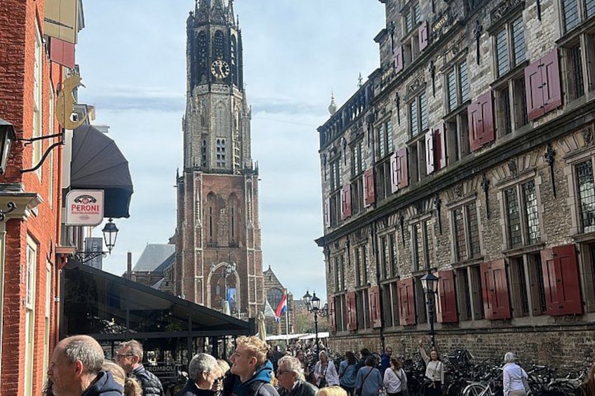 A crowded street with a historic clock tower in the background. 4