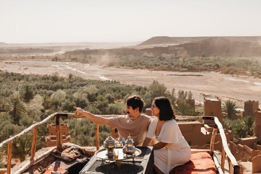 A couple dining at a table with a view of a desert landscape. 4