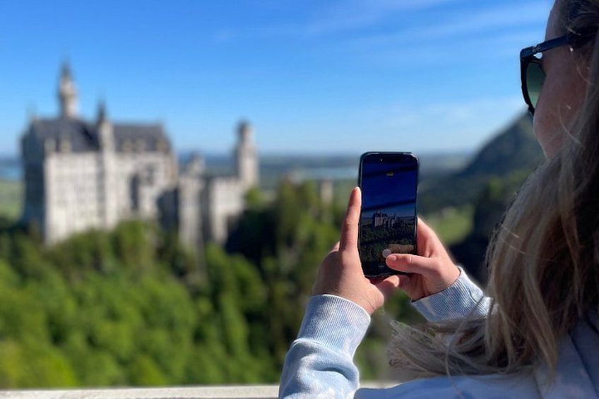 A person taking a photo of a castle with a smartphone. 4