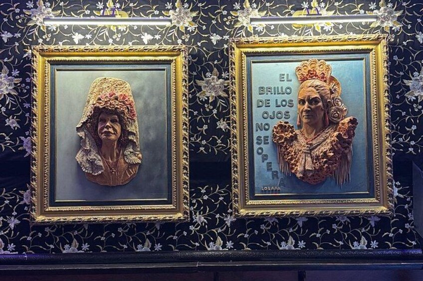 Two framed sculptures with intricate details and text on a patterned wall. 1