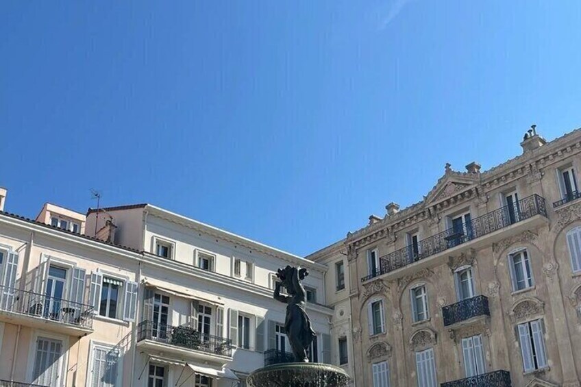 Une statue se dresse sur une place, avec des bâtiments en arrière-plan. 2