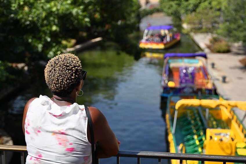 A person observing colorful boats on a river. 5