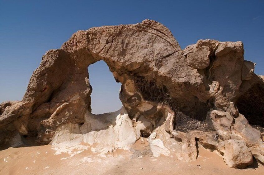 A natural rock arch formation in a desert landscape. 5