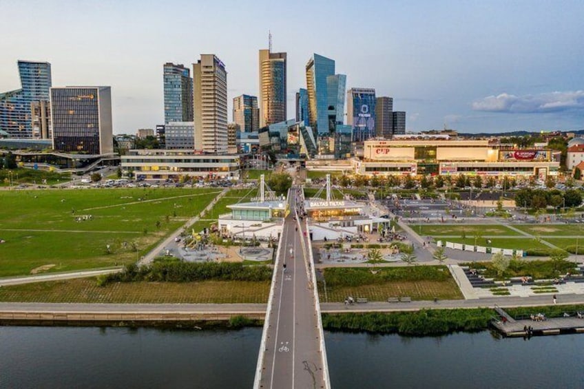 A city skyline with modern buildings, a bridge, and a river. 3